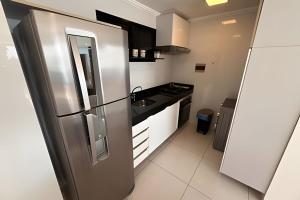 una cucina con frigorifero in acciaio inossidabile e lavandino di Hosts BR - Flat frente mar c/ cozinha a Fortaleza