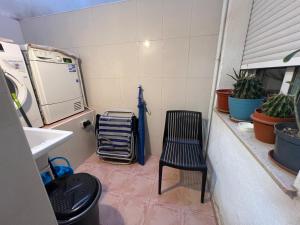 a kitchen with a sink and a chair and a washing machine at Apartamento céntrico junto paseo, playas y zonas de interés!! in Águilas +16 photos