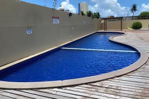 uma piscina ao lado de um edifício em Hosts BR - Flat frente mar c/ cozinha em Fortaleza