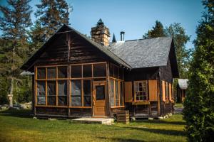 uma casa de madeira com uma chaminé por cima. em Rivière Petit Saguenay em Petit-Saguenay