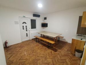 a room with a wooden table and a wooden floor at V&U Sobe in Brzi Brod