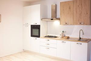 a kitchen with white cabinets and a stove top oven at Plebiscito House in Castel di Sangro