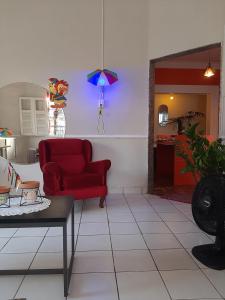 Oxen Hostel 2024 في ريسيفي: غرفة معيشة مع أريكة حمراء وطاولة