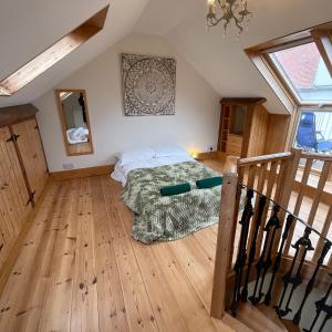 1 dormitorio con 1 cama y suelo de madera en The Sandgate Cottage, en Sandgate
