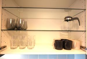 a shelf with cups and glasses on it at Centrally located 2-room apartment in Hannover
