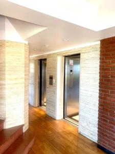 a hallway with a brick wall and a glass elevator at Hermoso departamento frente al golf !!! in Mar del Plata