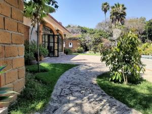 un chemin en pierre menant à une maison avec un palmier dans l'établissement Quinta Zana Hotel Boutique, à Cuernavaca