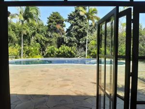 - une vue sur la piscine par une porte en verre dans l'établissement Quinta Zana Hotel Boutique, à Cuernavaca