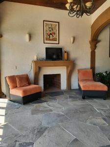 - un salon avec deux chaises et une cheminée dans l'établissement Quinta Zana Hotel Boutique, à Cuernavaca