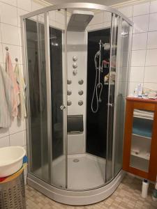 W łazience znajduje się prysznic ze szklanymi drzwiami. w obiekcie 2 bedroom luxury apartment seafront, free pick up! w mieście Tromsø