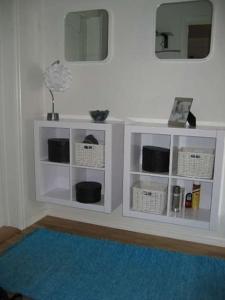 biała półka w pokoju z niebieskim dywanem w obiekcie 2 bedroom luxury apartment seafront, free pick up! w mieście Tromsø