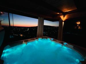 a bath tub in front of a window with a view at Panoráma Vendégház in Pécs