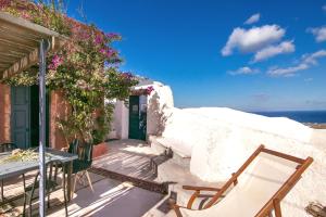 a patio with a table and chairs and the ocean at The Red Winehouse in Foinikiá +29 photos