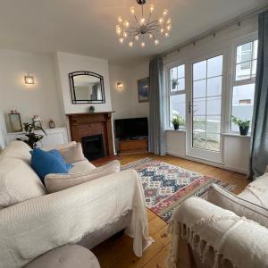 a living room with a couch and a chandelier at The Sandgate Cottage in Sandgate