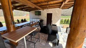 a patio with a table and chairs and a television at Villa LANA Krupa na Vrbasu in Banja Luka