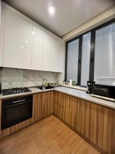 uma cozinha com armários brancos e um aparelho preto em Apartment in the Centre em Yerevan