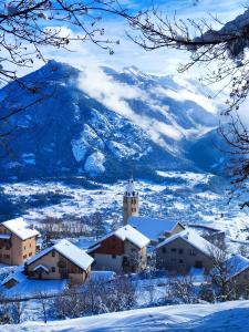 a town in the snow with a mountain in the background at Auberge La maison de Catherine in Puy-Saint-Pierre