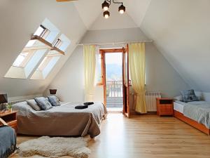 een slaapkamer op zolder met 2 bedden en een raam bij Willa Żółta Turnicka in Zakopane
