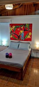 a bedroom with a bed with a painting on the wall at Alta Vibra Appartement in Sámara
