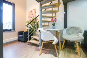a living room with a spiral staircase and a table and chairs at E102 Urban loft vista in Coventry