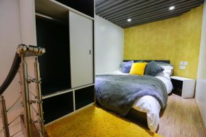 a bedroom with a bed and a yellow wall at E102 Urban loft vista in Coventry