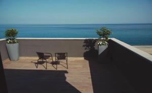 2 stoelen op een balkon met uitzicht op de oceaan bij Il Vicoletto Bovalino - B&B in Bovalino Marina