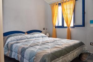 a bedroom with a bed with a blue headboard and a window at Casa Azzurra in Cala Gonone
