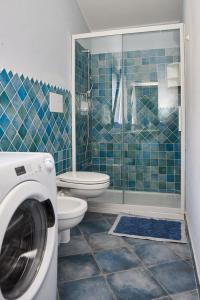 a bathroom with a toilet and a washing machine at Casa Azzurra in Cala Gonone