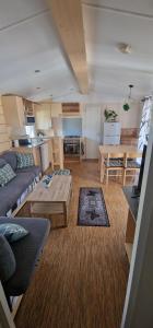 - un salon avec un canapé et une table dans l'établissement Mobil-home de vacances, à Le Bosc