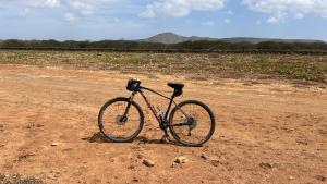 a bike parked in the middle of a dirt road at Quintal do Maio in Vila do Maio