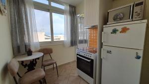 a kitchen with a refrigerator and a table and a window at Tomis Sea View Apartment in Piraeus