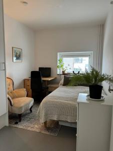 a bedroom with a bed and a chair and a table at The favorite room in a shared apartment in Nacka