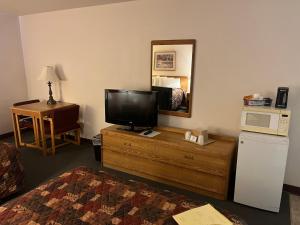 een hotelkamer met een televisie op een dressoir met een bed bij Country Haven Inn in Burlington