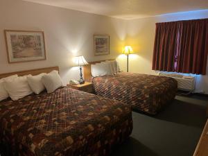 een hotelkamer met 2 bedden en een raam bij Country Haven Inn in Burlington