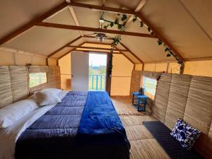 蘇埃斯卡的住宿－Coclí Glamping Suesca，帐篷内一间卧室,配有一张大床