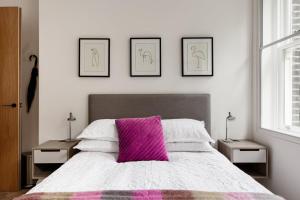 a bedroom with a large bed with a pink pillow at Modern Apartment & Rooms at Charing Cross in London