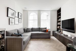 ein Wohnzimmer mit einem Sofa und einem Flachbild-TV in der Unterkunft Modern Apartment & Rooms at Charing Cross in London