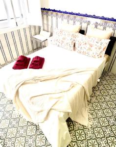 a bedroom with a bed with red pillows on it at Zenit charm Olhao relax cubist House in Olhão