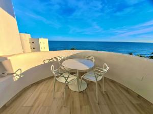 a table and chairs on a balcony with the ocean at Algaida, beach apartment in Mijas Costa