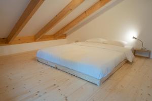 1 dormitorio con 1 cama blanca en el ático en Rückzugsort mitten im Paradies en Feldafing