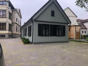 una casa que está sentada en una entrada de ladrillo en Garden House en Liepāja
