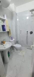 a white bathroom with a toilet and a sink at Perla Apartment 3 in Golem