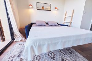 una camera da letto con un letto con copriletto bianco di Studio standing - Village Lumio a Lumio