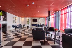 Halmstad Hotel Apartments في هالمستاد: مطعم بطابق متقاطع وطاولات وكراسي