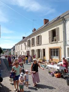 a group of people walking down a street at Charmante et spacieuse maison de village in Courdemanche