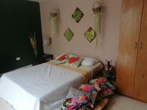 Un dormitorio con una cama blanca con almohadas. en Glamping Bambulina, en Cali