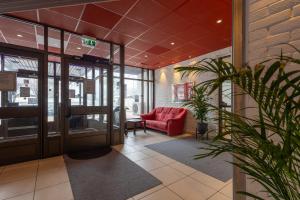 un hall avec une chaise rouge dans un bâtiment dans l'établissement Halmstad Hotel Apartments, à Halmstad