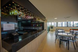 a restaurant with a bar with tables and chairs at HOTEL GRAN PREMIUM PLAZA LTDA in Muriaé