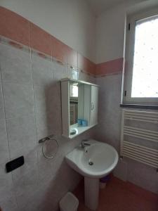 baño con lavabo, espejo y ventana en Sunset Shores Oasis - Gulfview Haven Rooms with a View, strategic for Pompeii, Amalfi, Capri, and on the Road to Sorrento- progetto sociale Artigiani della preziosità en Castellammare di Stabia