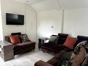 a living room with two couches and a flat screen tv at Woodhouse Retreat in Woodhouse